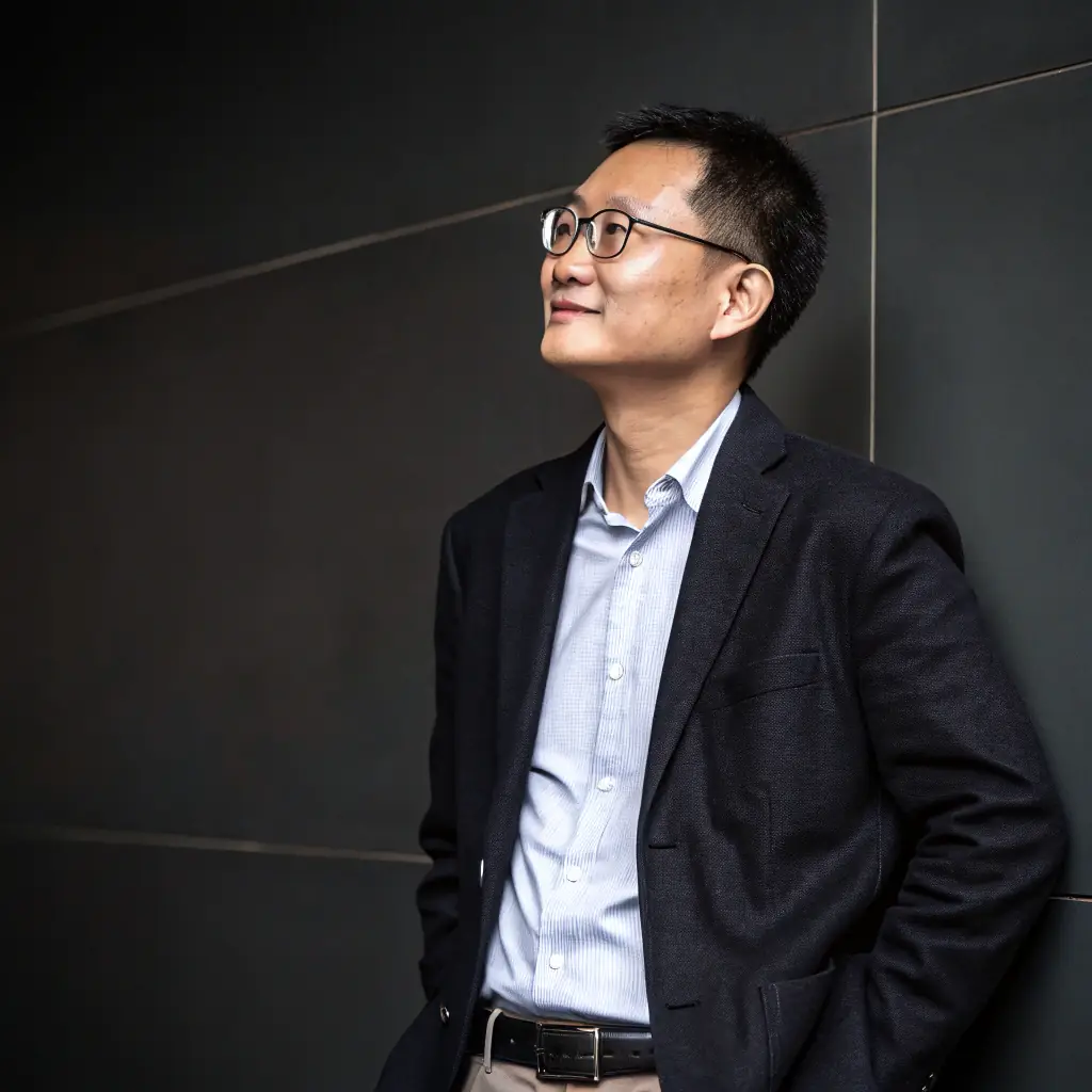 Kenji has a stern look, with neatly combed black hair and a professional, minimalist attire.