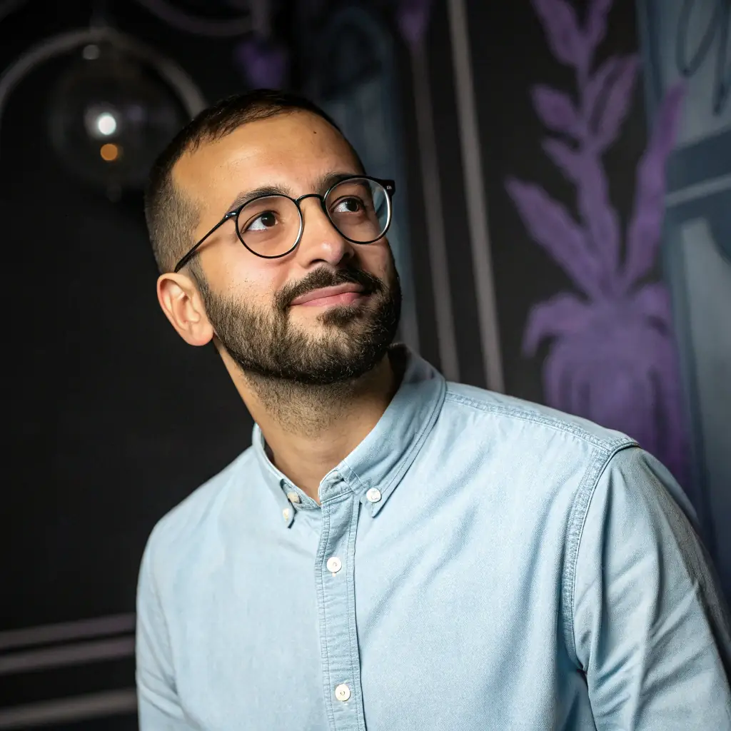 A professional headshot of David Lee, a man with glasses and a neatly trimmed beard, wearing a button-down shirt, looking directly at the camera.