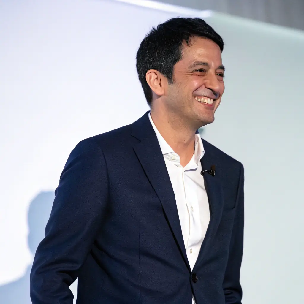 Professional headshot of a smiling client, offset to the right, wearing a business suit.