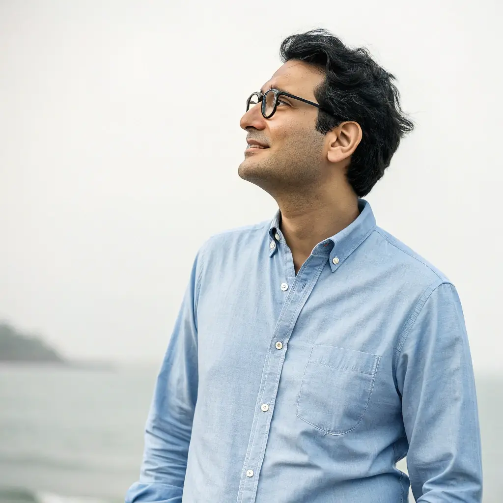 Professional headshot of a smiling client, offset to the right, wearing glasses and a formal shirt.