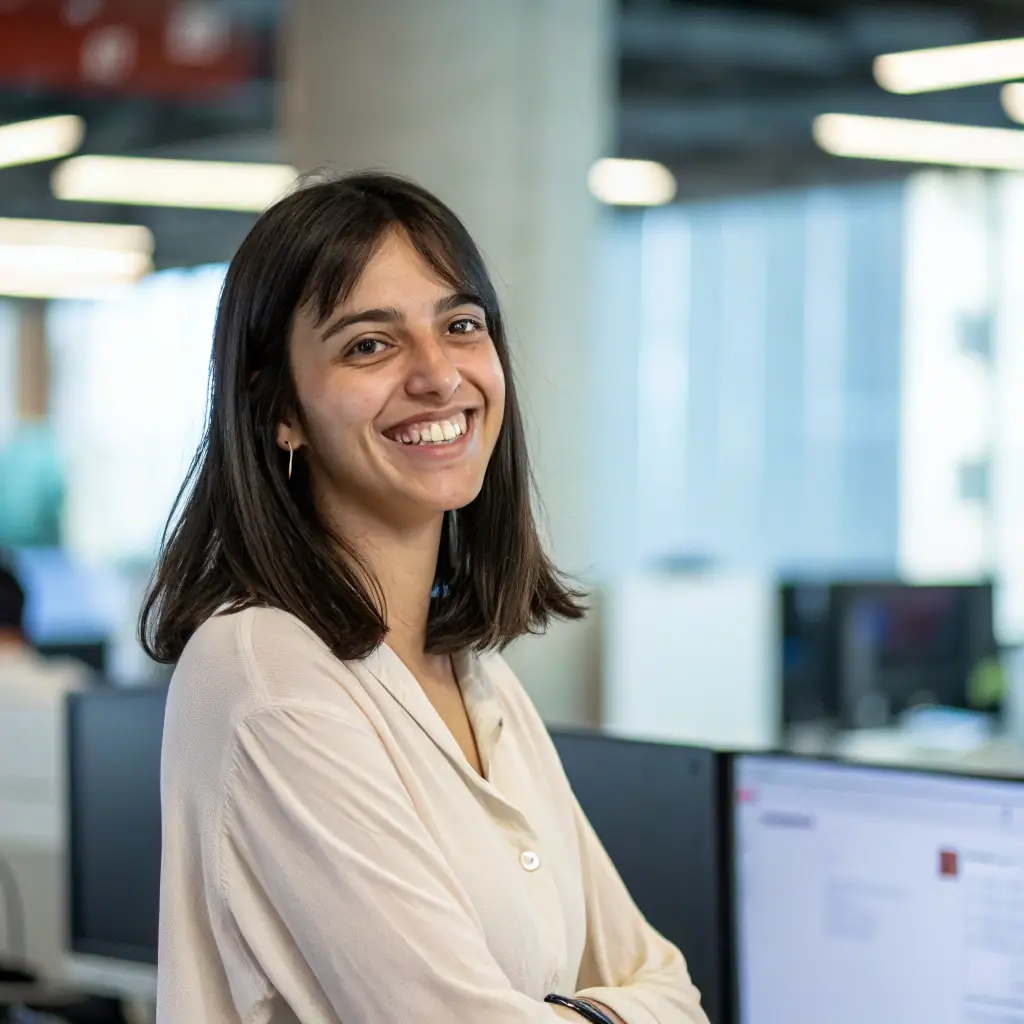 Dr. Sharma has a warm smile, with her dark hair neatly pulled back, and she wears glasses that reflect her deep understanding of technology.
