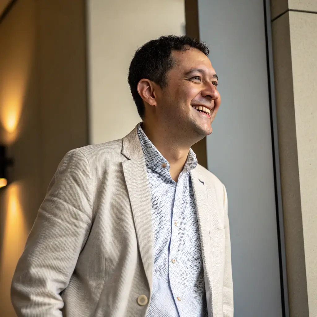 A professional headshot of John Smith, a man with short dark hair, wearing a button-down shirt and smiling warmly.