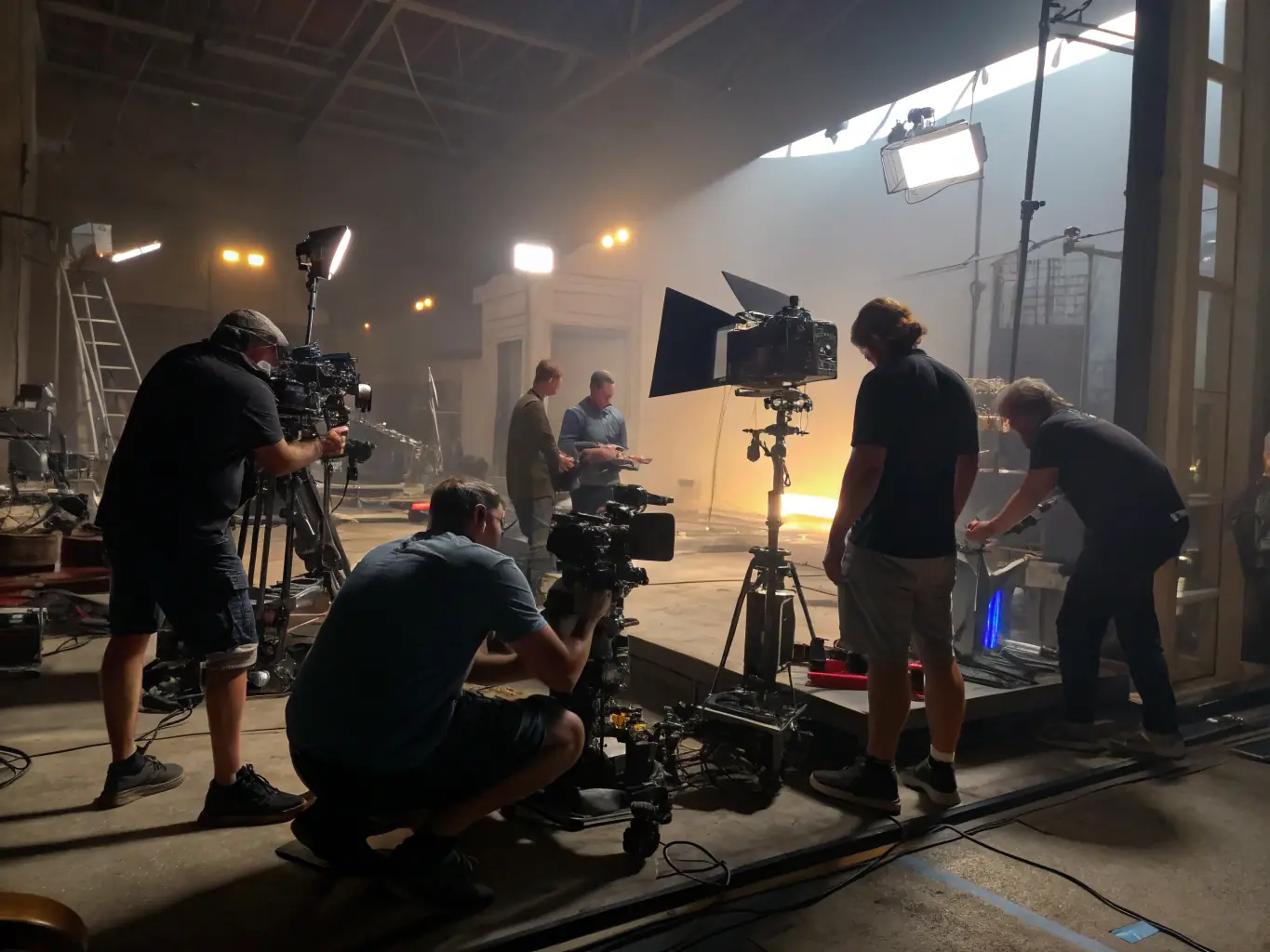 A film camera lens focusing on a group of people working on a film set, with warm lighting and a sense of collaboration.