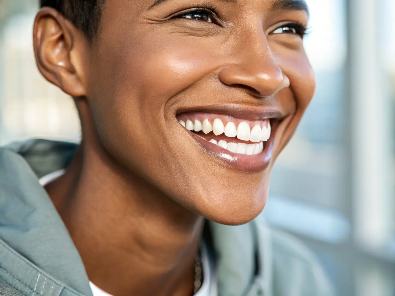 A close-up of a person smiling, showing their perfectly aligned and natural-looking dental implants.